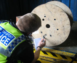 A BTP officer checks a cable drum